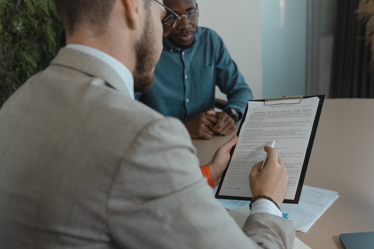 A recruiter reviews a candidate's documents during a job interview in a modern office setting.